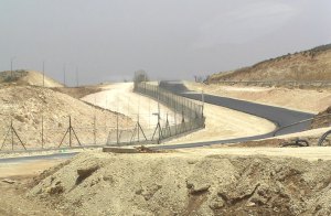 Der Grenzzaun mit Sandweg und geteerter Strasse südlich von Hebron. Foto: E. Scheiner